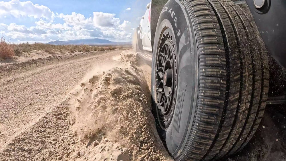 Pirelli Scorpion AS Plus 3 tyre throwing loose sand beside a Ford Ranger Raptor